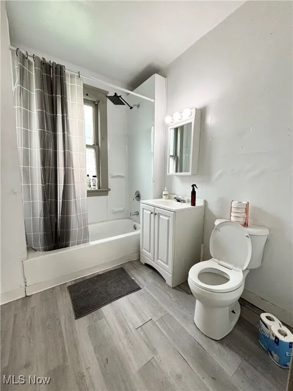 Bathroom featuring shower / bath combo, vanity, and light wood-style floors