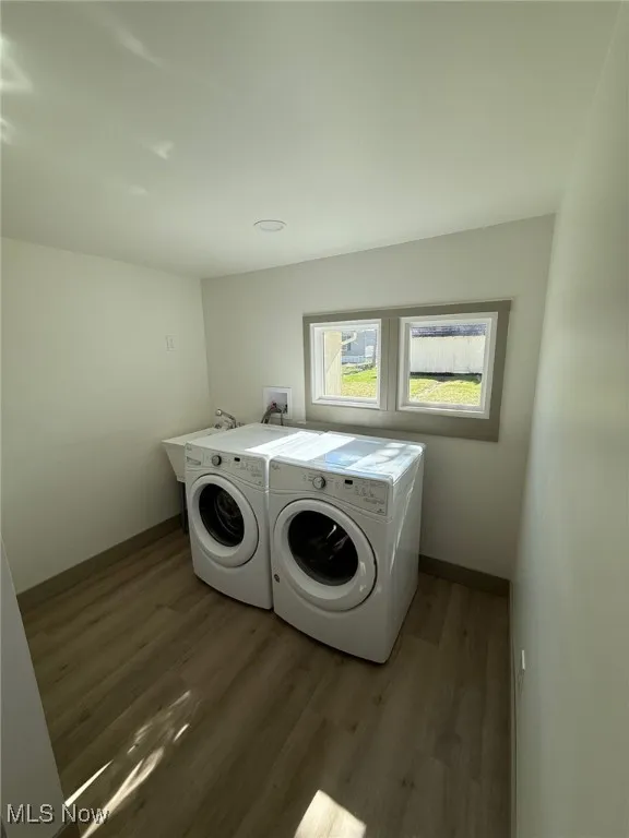 Washroom featuring dark wood-style flooring and independent washer and dryer