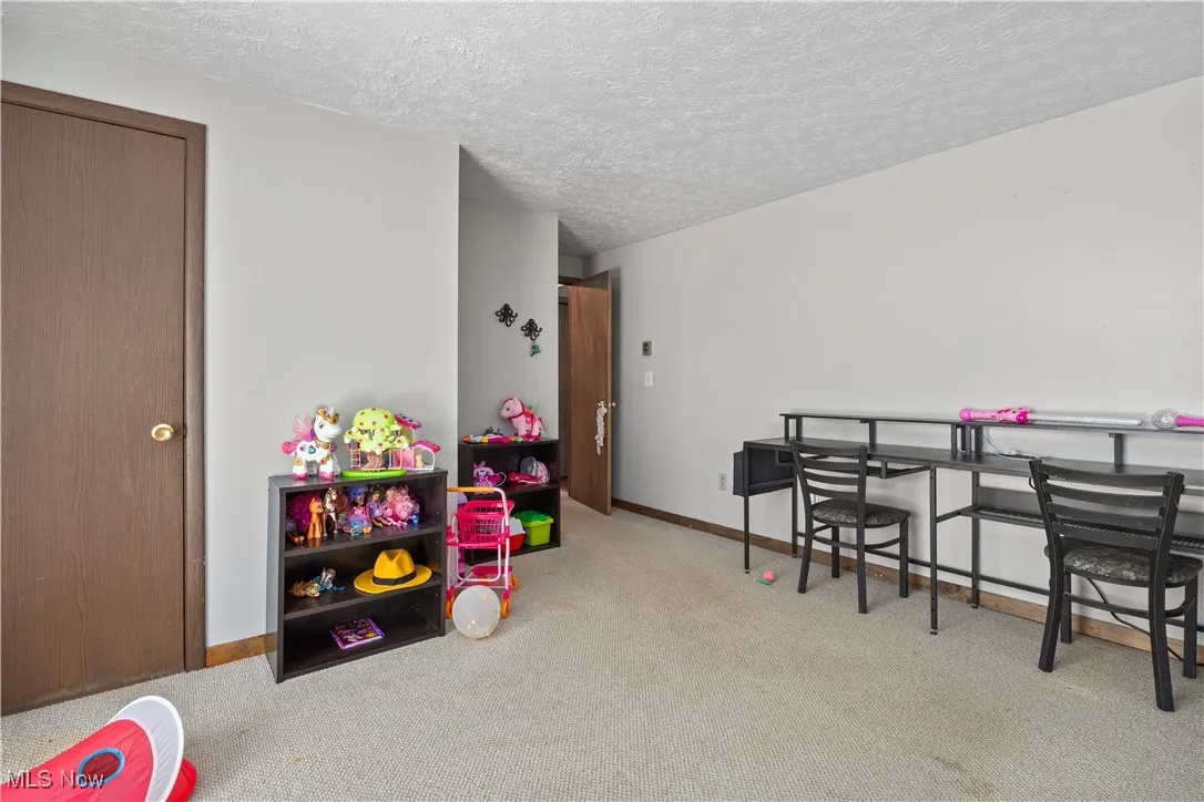 First floor bedroom with carpet flooring and a textured ceiling