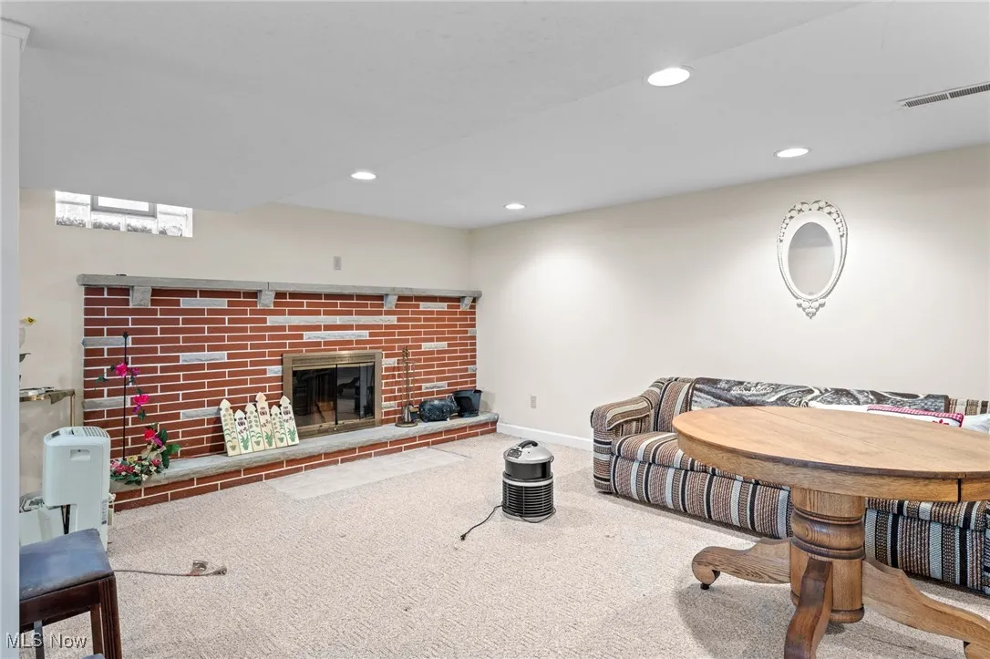 Living area featuring recessed lighting, carpet flooring, and a brick fireplace