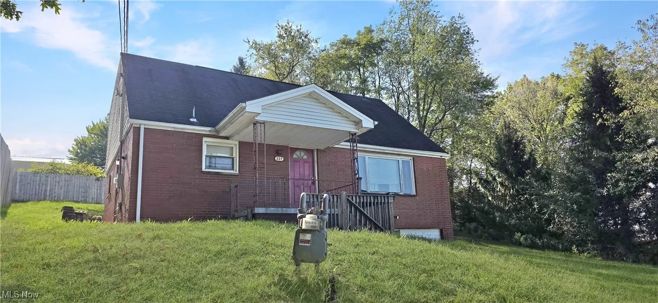 Bungalow-style home with brick siding and roof with shingles