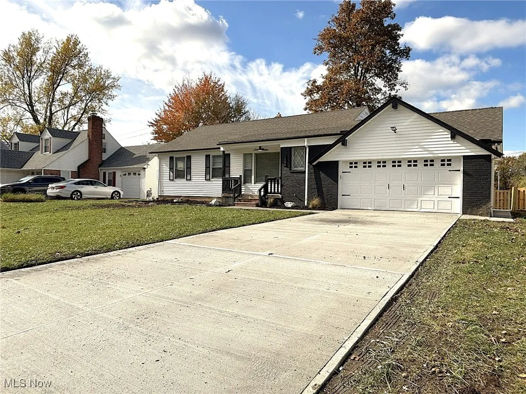 Single story home with driveway, a front yard, a garage, and brick siding