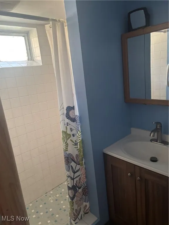 Full bath featuring a shower stall and vanity
