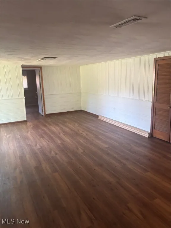 Spare room featuring dark wood-type flooring