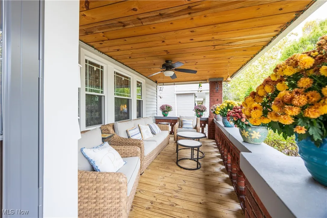 Wooden terrace with an outdoor hangout area and ceiling fan