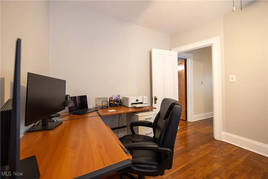 Office space featuring dark wood-style floors and baseboards