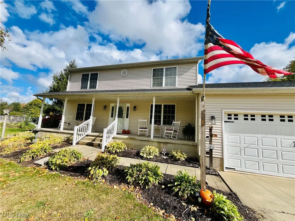 View of front facade featuring a porch, a garage, and concrete driveway