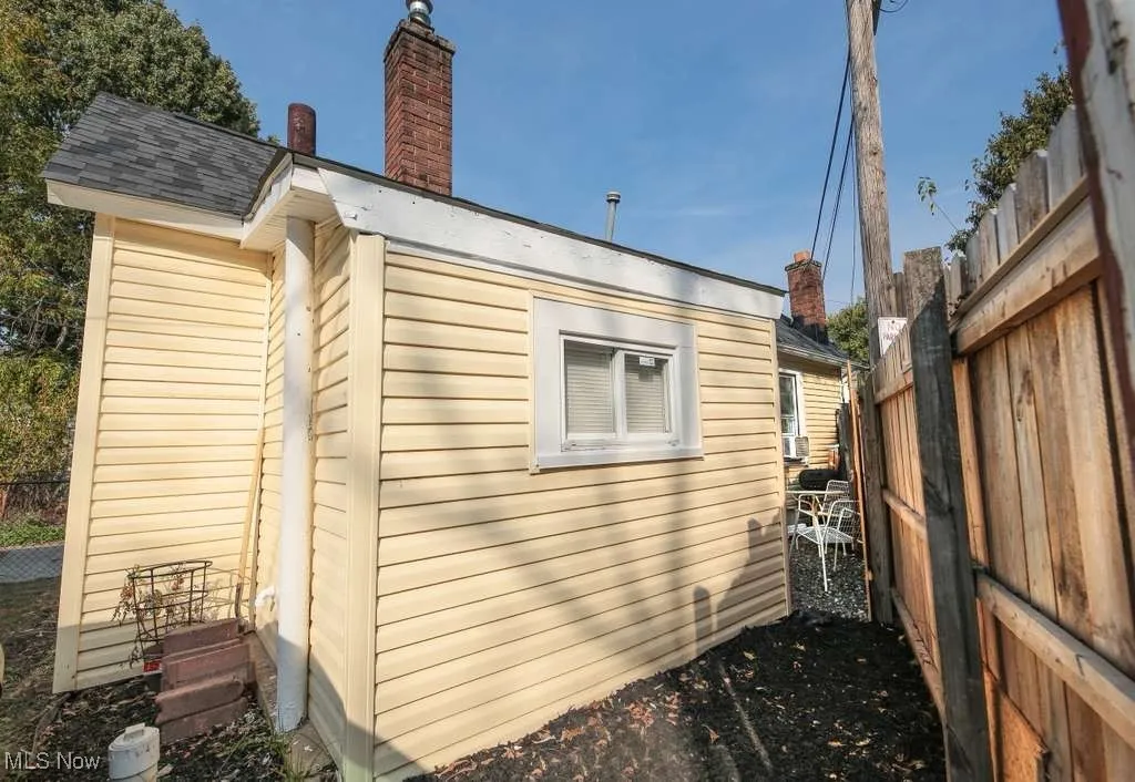 View of side of property featuring a chimney and a shingled roof