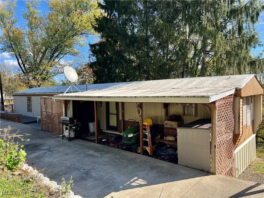 View of property exterior with a metal roof and a carport