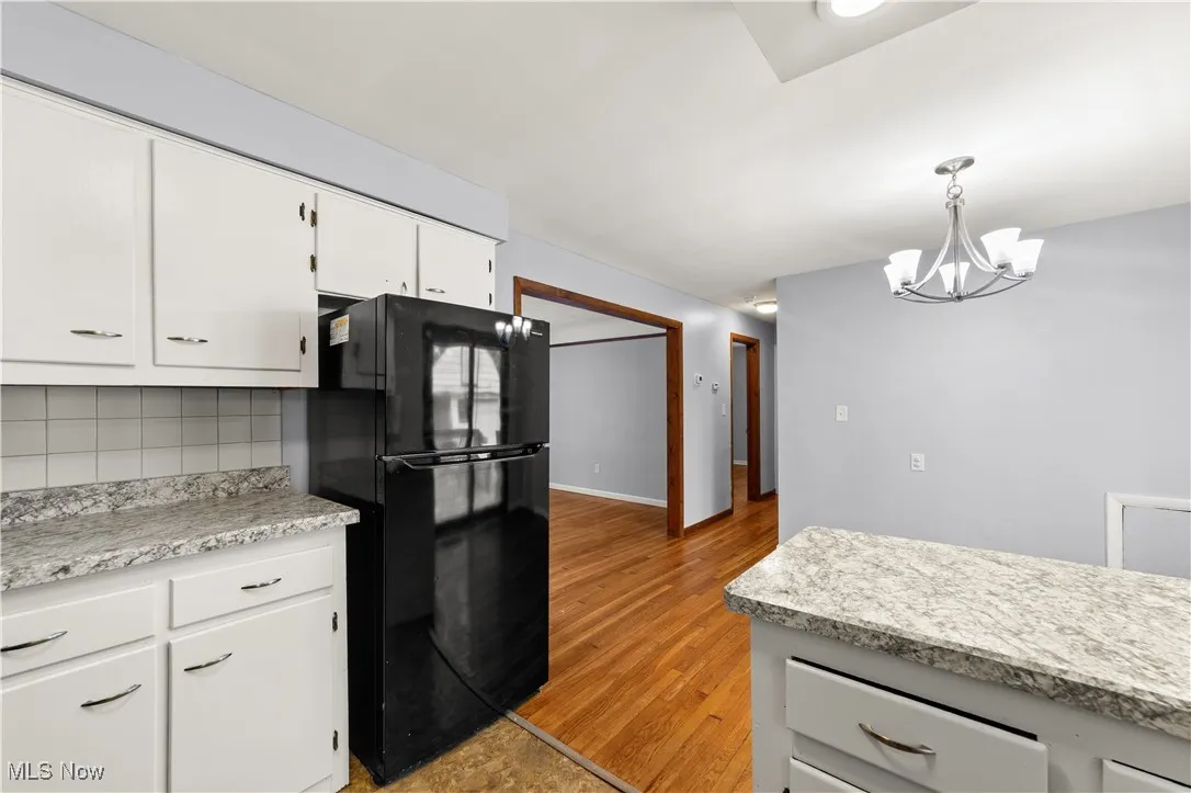 Kitchen with white cabinets neutral counters and newer appliances