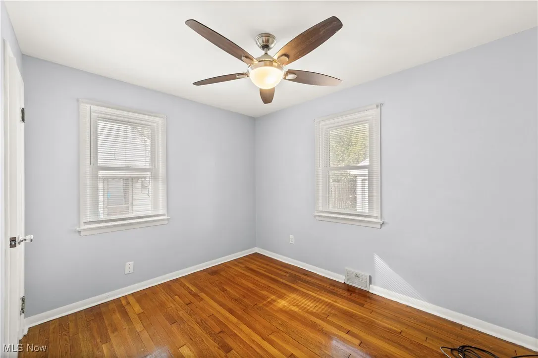 Bedroom with hardwood floors neutrally painted and ceiling fan