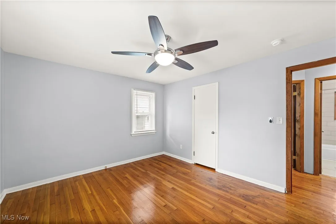 Bedroom with hardwood floors neutrally painted and ceiling fan