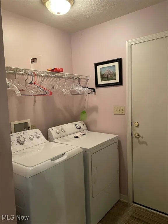 Washroom featuring a textured ceiling and independent washer and dryer