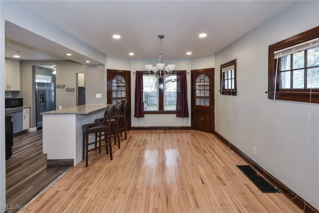 Dining room with light wood-style floors, a chandelier, and recessed lighting