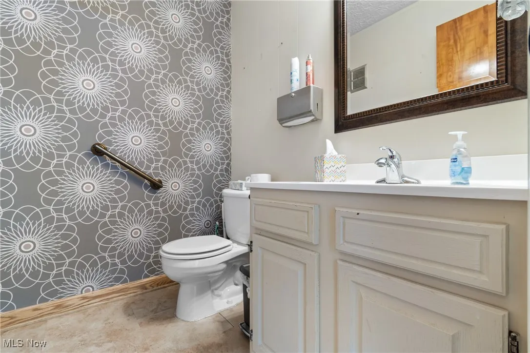 Bathroom featuring vanity, light tile patterned floors, and a textured ceiling