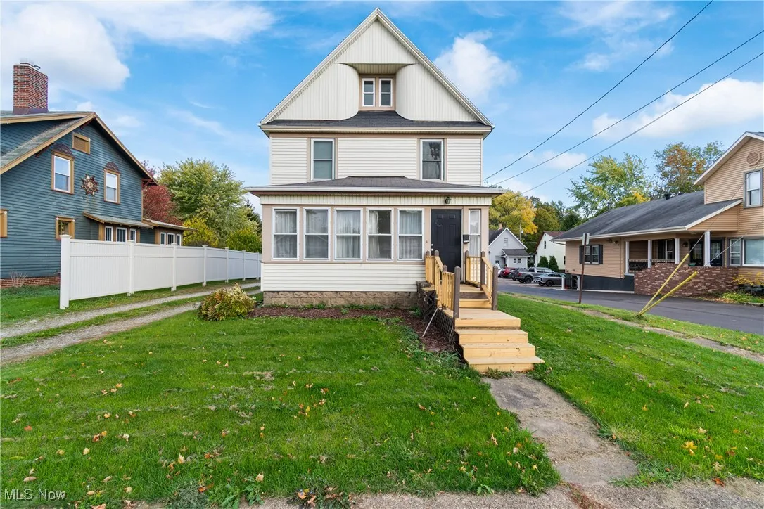 American foursquare style home featuring a sunroom and board and batten siding