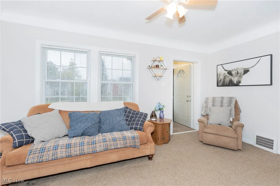 Living room with carpet floors and a ceiling fan