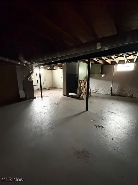 Below grade area featuring stairs and heating unit