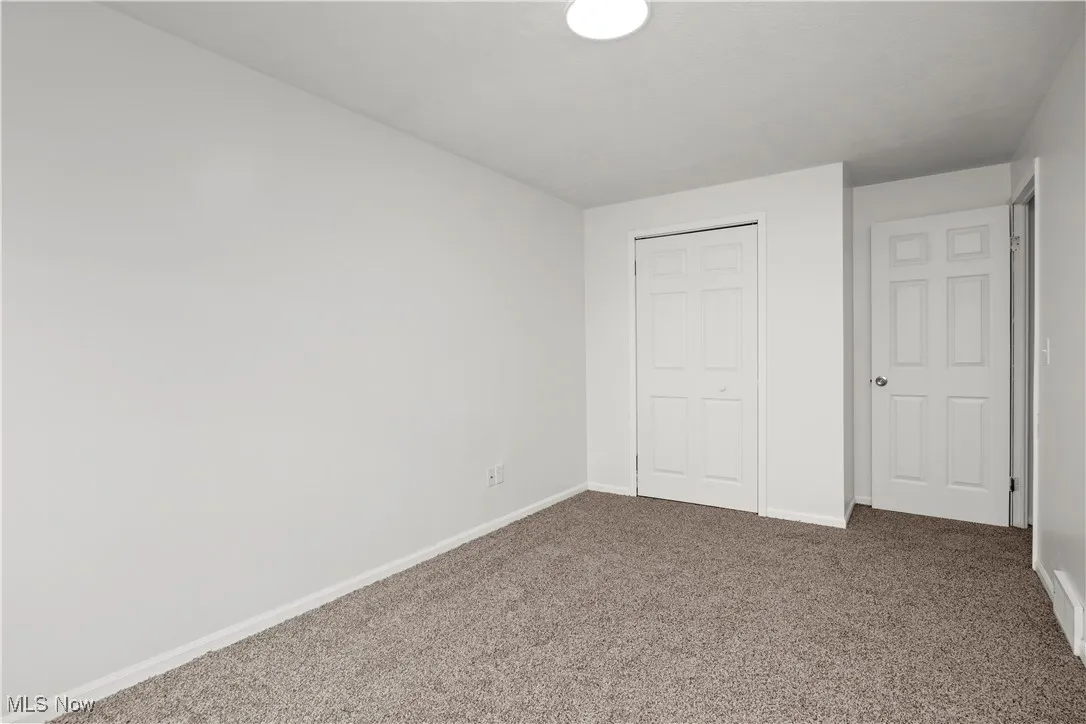 Unfurnished bedroom featuring carpet and a closet