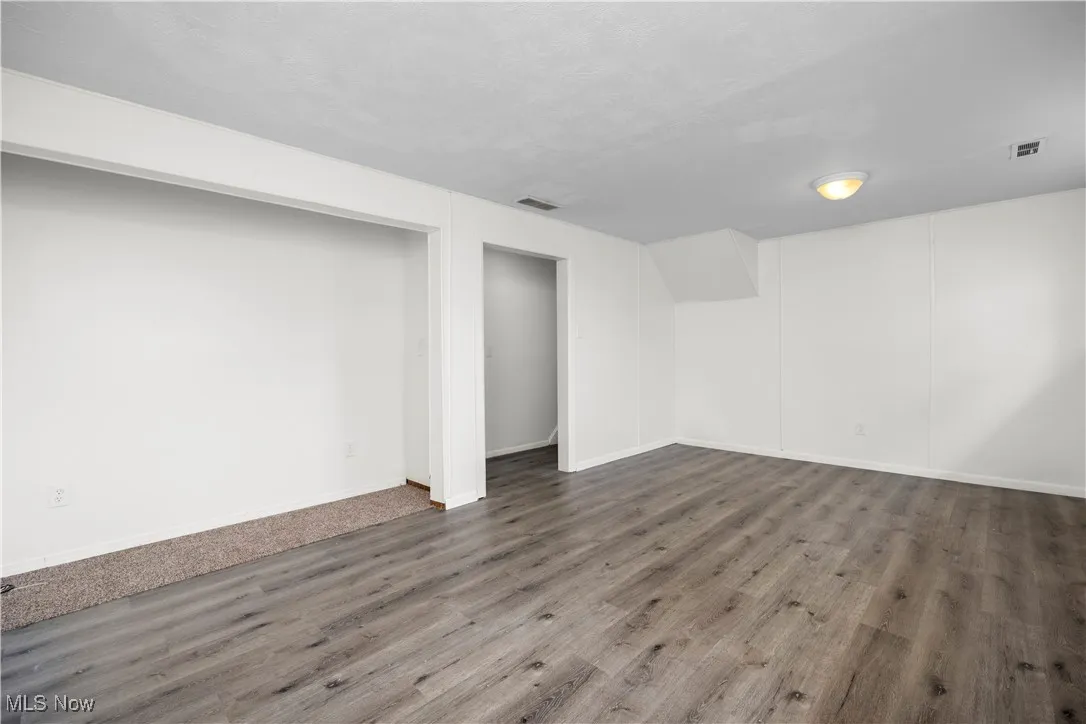Below grade area featuring wood finished floors and a textured ceiling