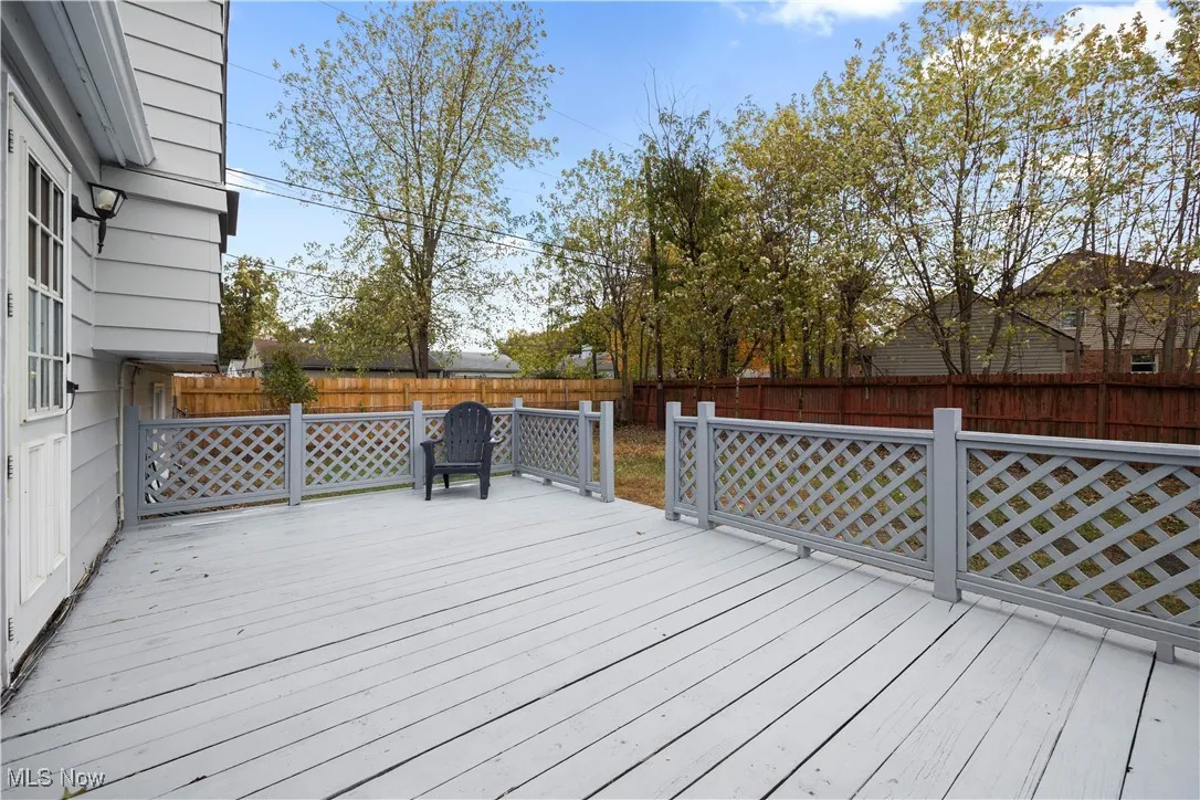 Wooden terrace with a fenced backyard
