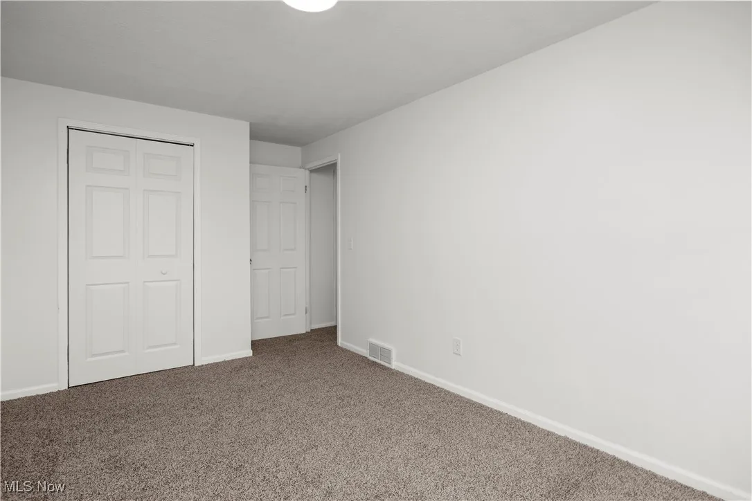 Unfurnished bedroom featuring a closet and carpet