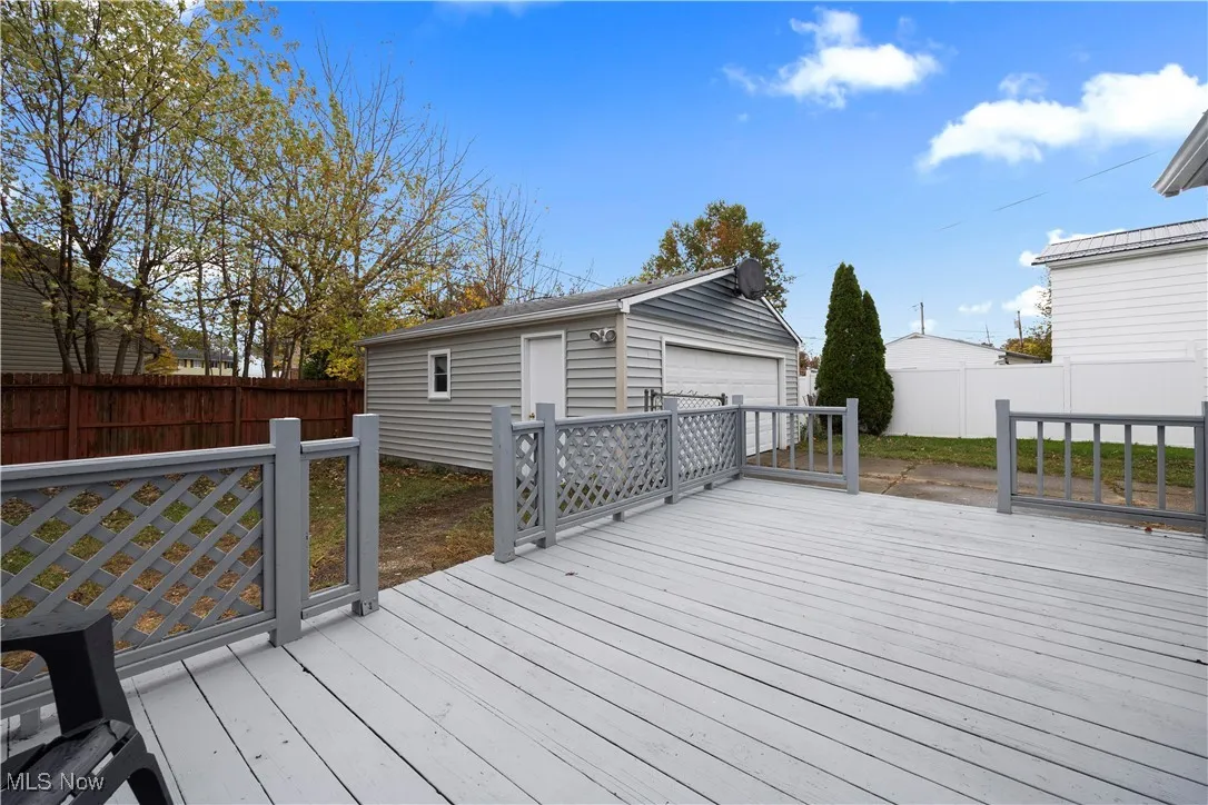Deck featuring an outdoor structure, a fenced backyard, and a detached garage