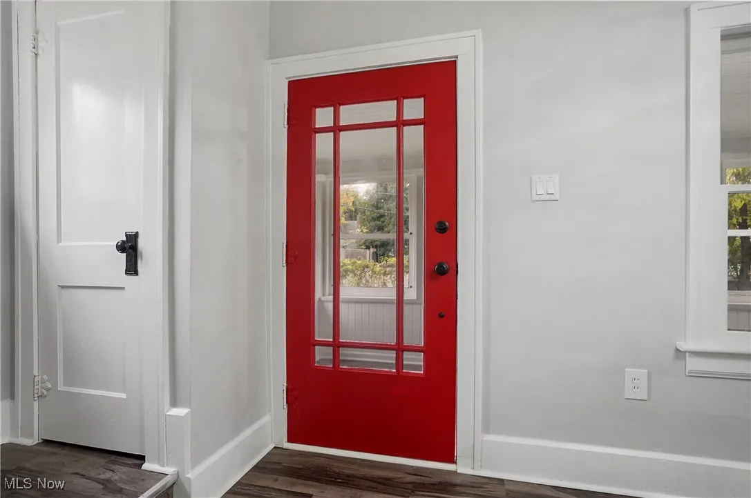 Entrance foyer with a textured ceiling, plenty of natural light, dark wood-style flooring, and arched walkways