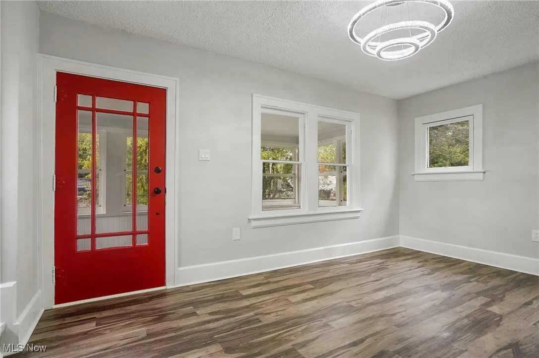 Foyer with dark wood finished floors and baseboards