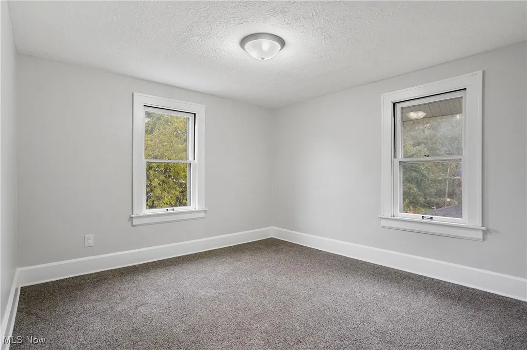 Spare room featuring carpet and a textured ceiling
