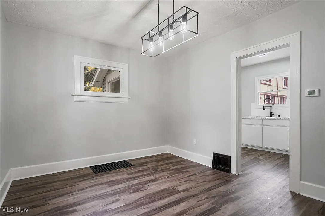 Spare room featuring dark wood-style floors and a textured ceiling