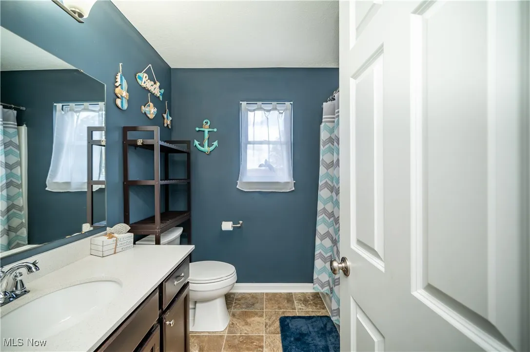 Bathroom with a shower with shower curtain and vanity
