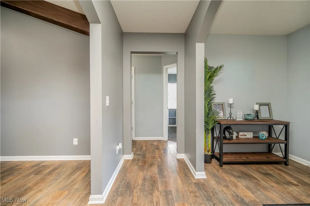 Corridor with wood finished floors and a textured ceiling