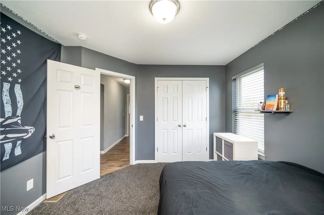 Carpeted bedroom featuring a closet and baseboards