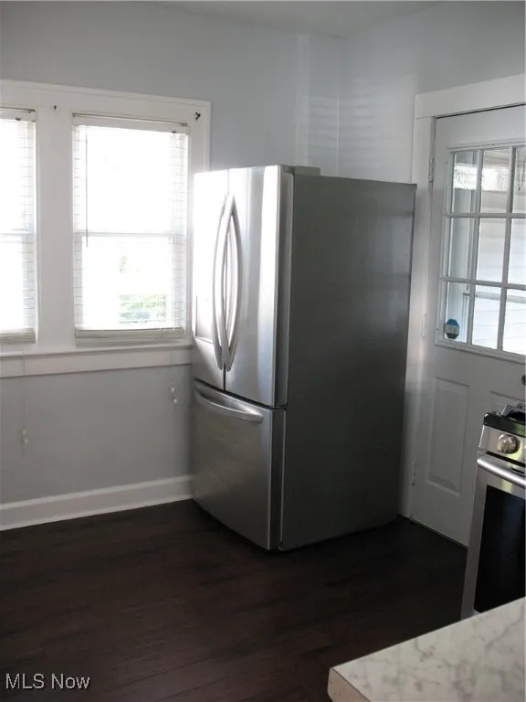 Kitchen with freestanding refrigerator, range, and dark wood-style flooring
