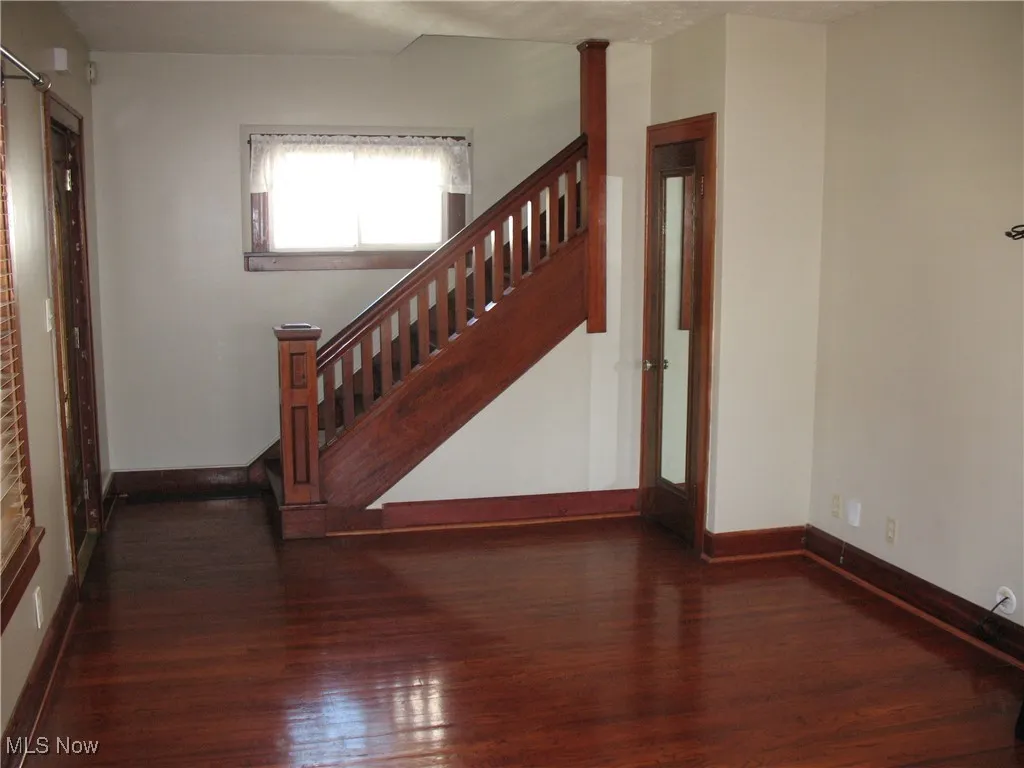 Stairway with hardwood / wood-style flooring and baseboards
