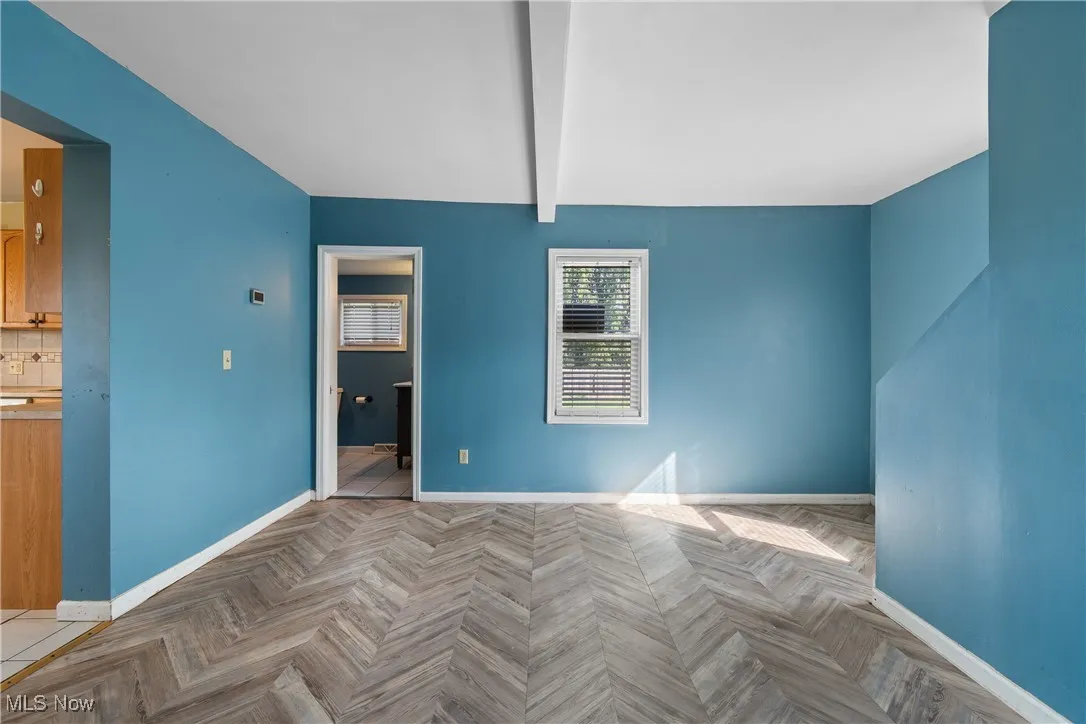 Living room with beam ceiling and baseboards