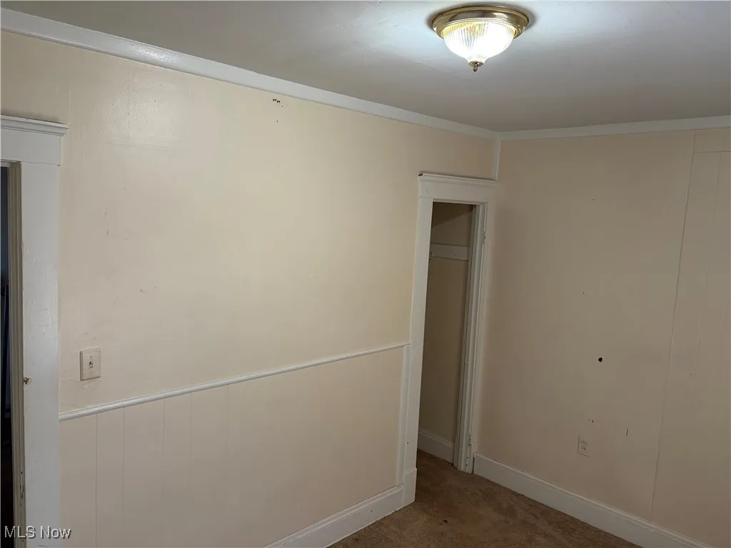 Carpeted empty room with baseboards