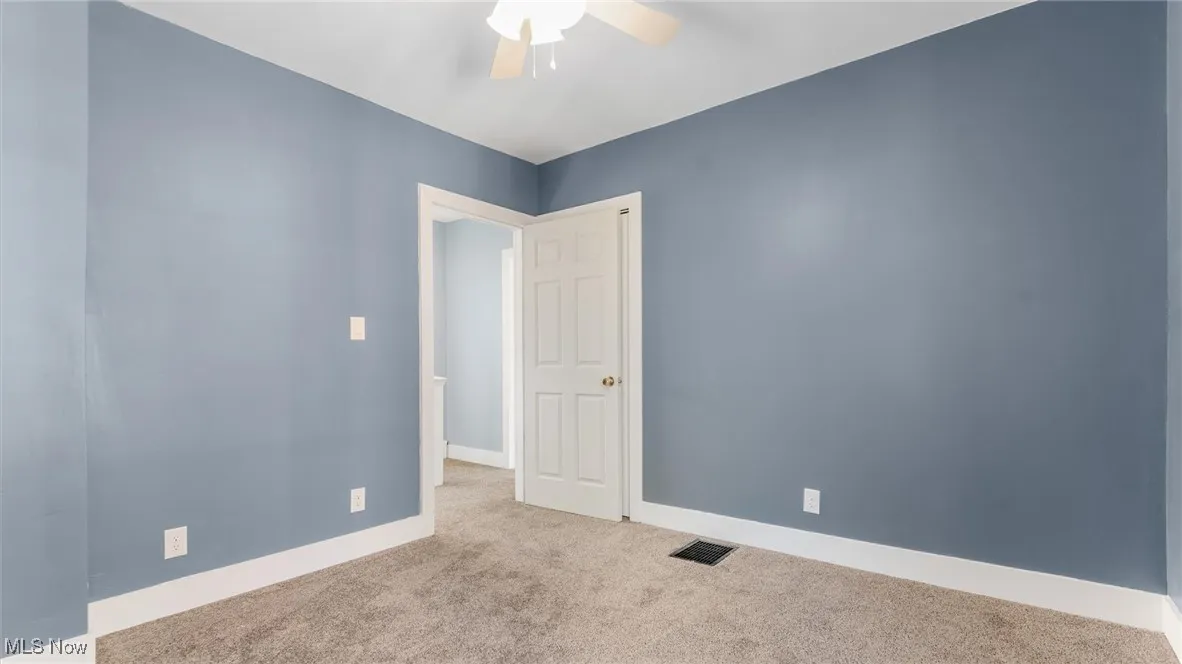 Spare room with carpet flooring and ceiling fan