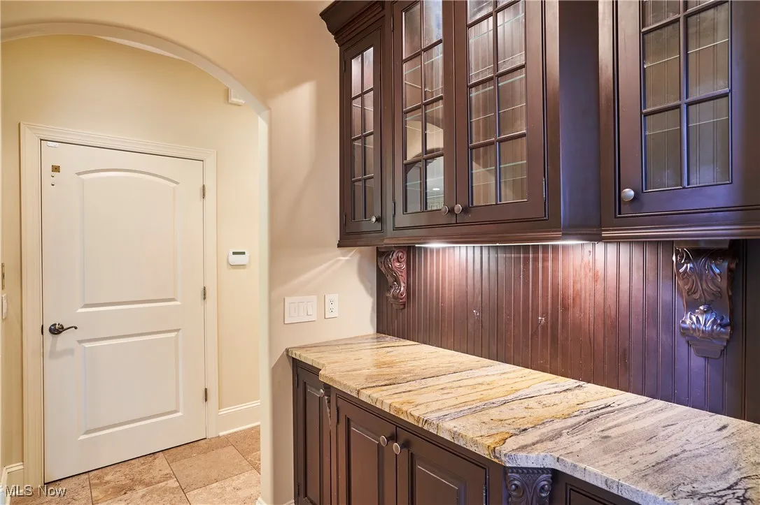 A butler pantry with serving cabinet with granite countertops