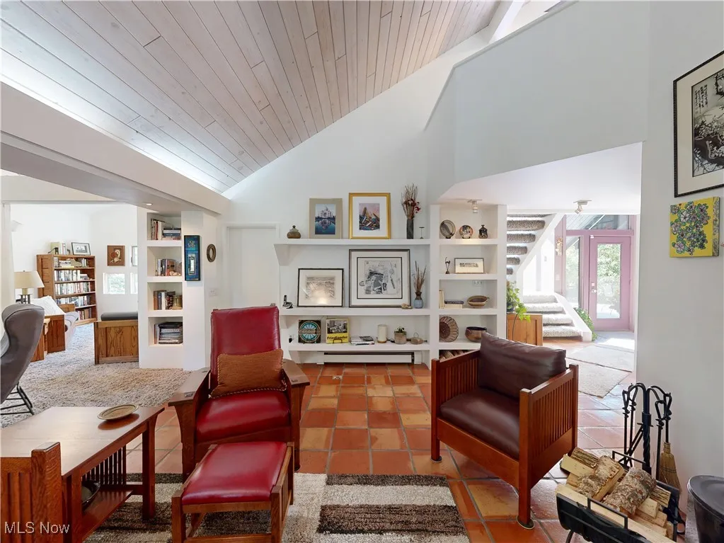 Living area with stairway, high vaulted ceiling, built in features, wood ceiling, and tile patterned floors