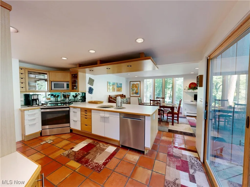 Kitchen with light countertops, a peninsula, stainless steel appliances, plenty of natural light, and recessed lighting