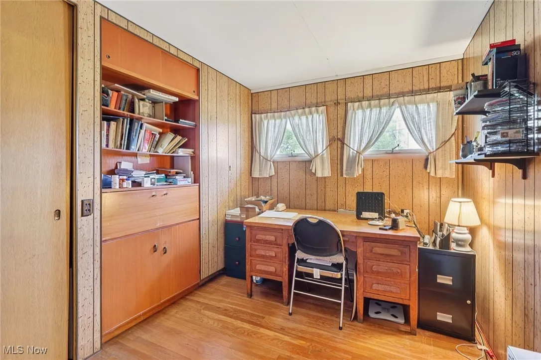 Home office featuring wood walls and light wood-type flooring