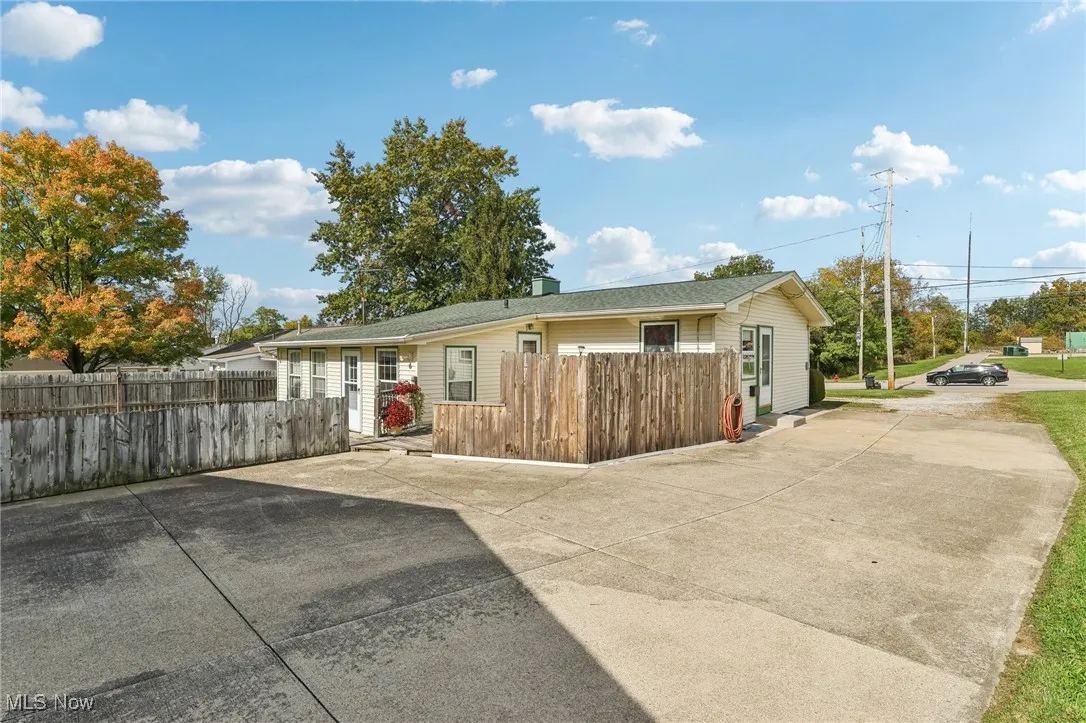 View of front facade featuring a chimney and driveway