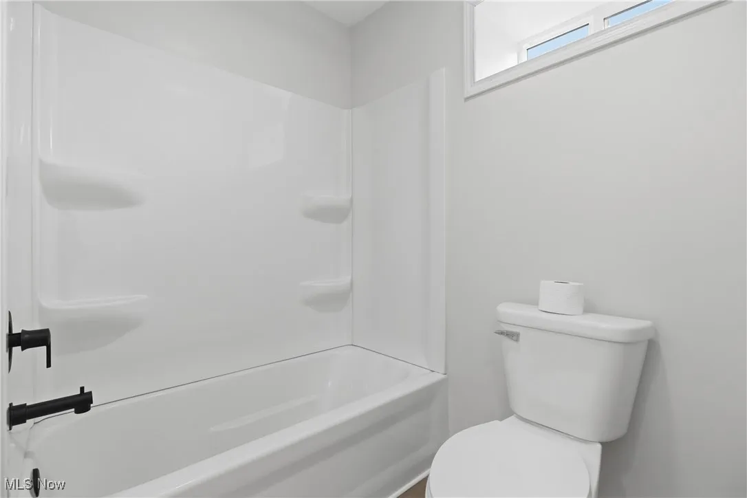 Bathroom with shower / bathtub combination and toilet