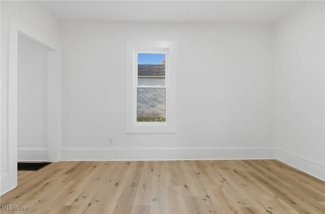 Spare room featuring wood finished floors and baseboards