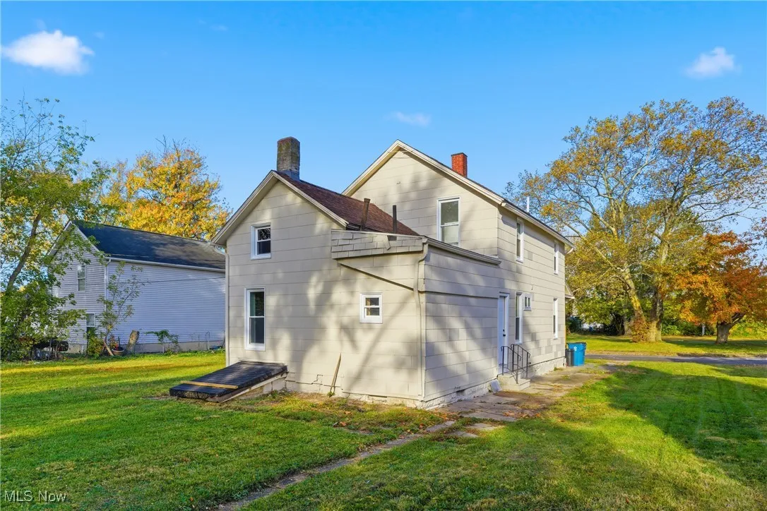 Rear view of property with a lawn and a chimney