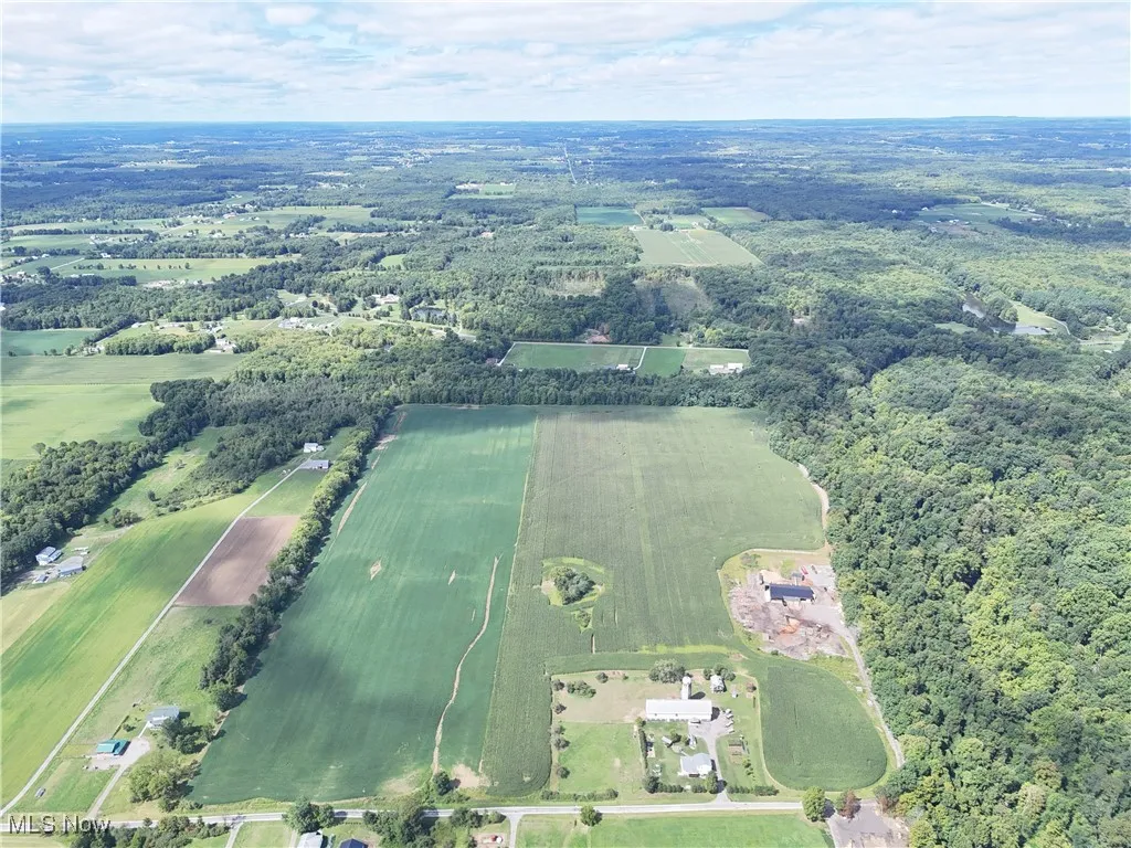 Aerial overview of property's location with a heavily wooded area and rural landscape
