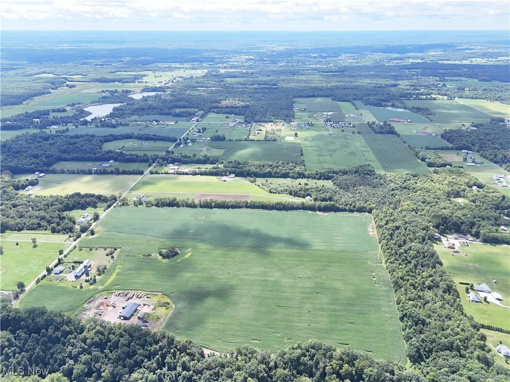 Aerial view of property's location featuring rural landscape and extensive farmland
