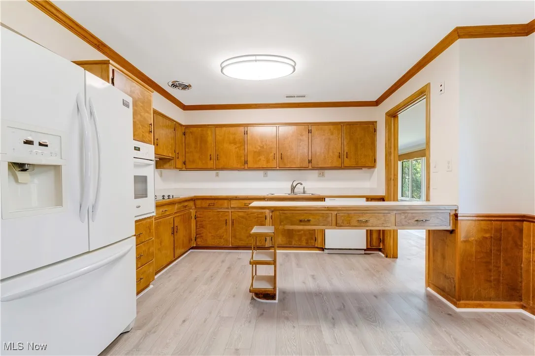 Kitchen with ornamental molding, LVT flooring.